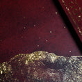 Load image into Gallery viewer, A close-up of the 13 moon journal 2027 dark burgundy textured surface with scattered small metallic gold star-like specks and a chunky gold foil mountain-like border along the bottom edge.