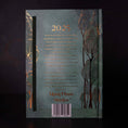 Load image into Gallery viewer, back of the 13 moon journal 2025 with green trees gold text and outlines