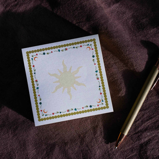 post-it note with sun design on a textured purple fabric surface